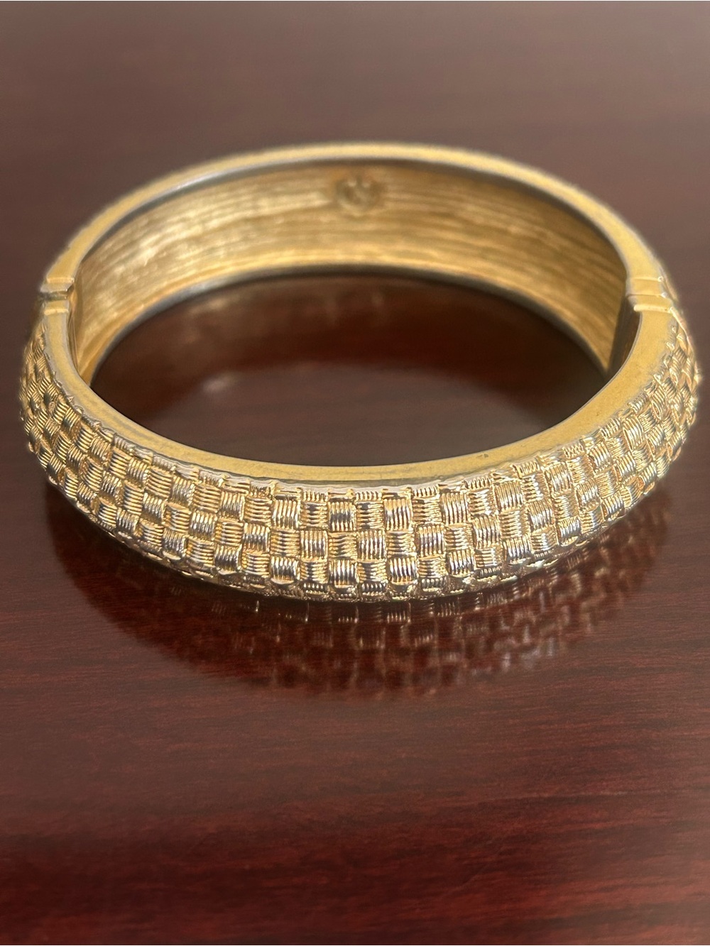 Vintage St.John textured gold tone basket weave hinged bangle bracelet. Signed.